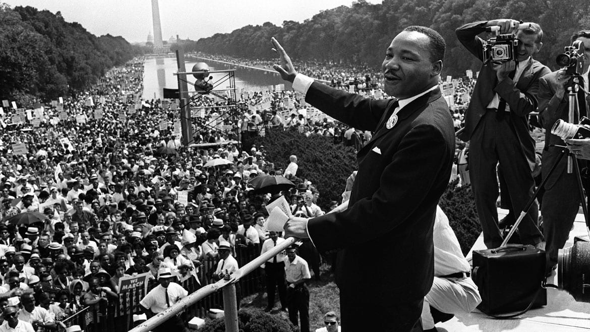 The civil rights leader Martin Luther King waving to supporters