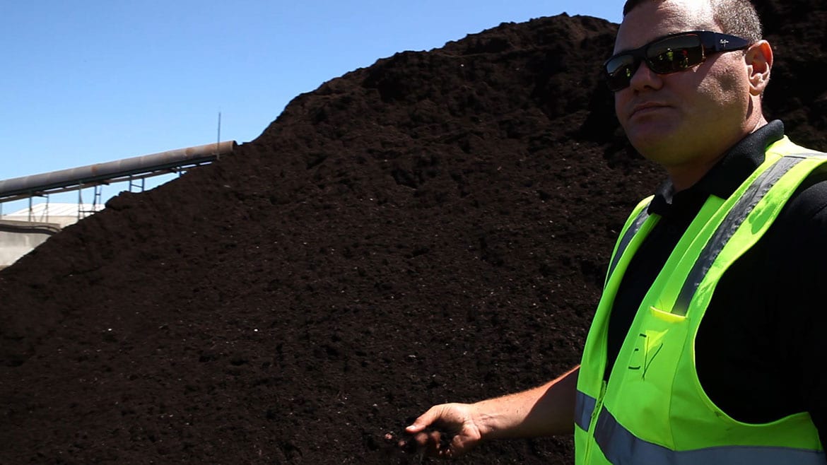 Man next to compost pile.
