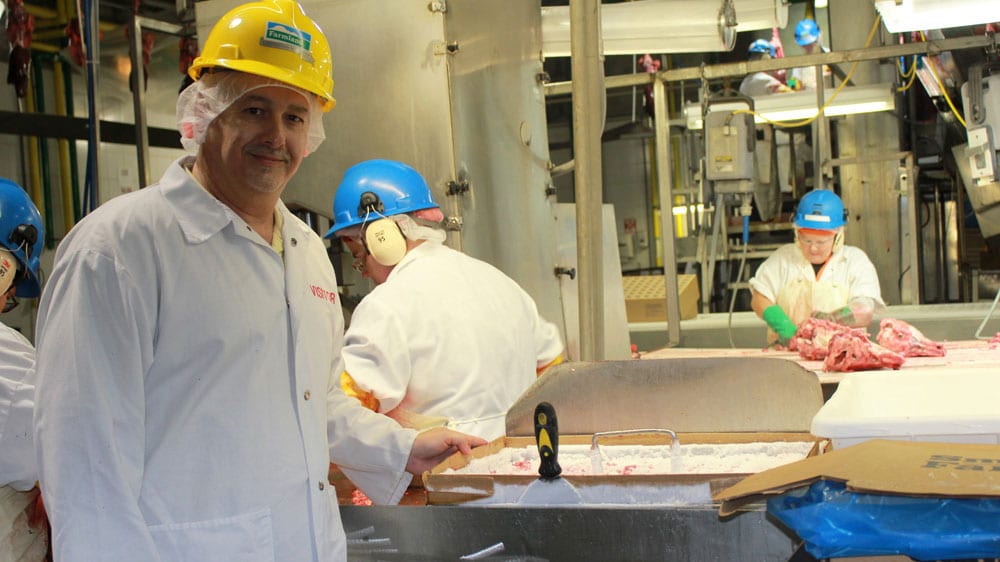 A worker looks out from the control room onto the rendering section of the Farmland Foods plant near Milan, Mo. (Peggy Lowe/Harvest Public Media)