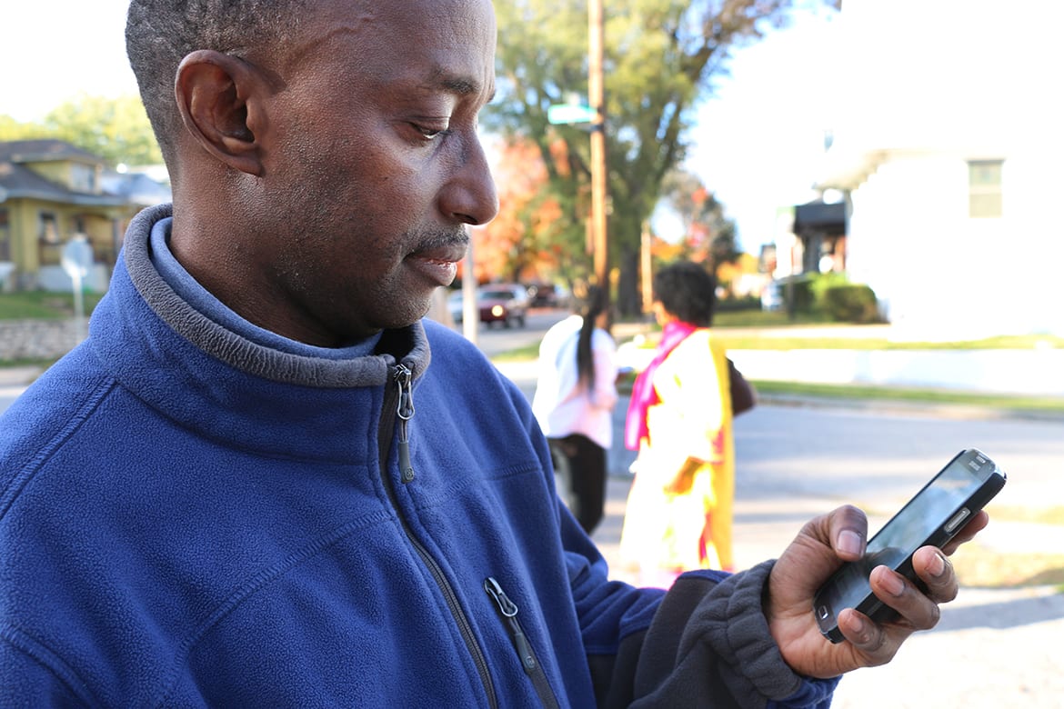 Photo of man looking at his cell phone.