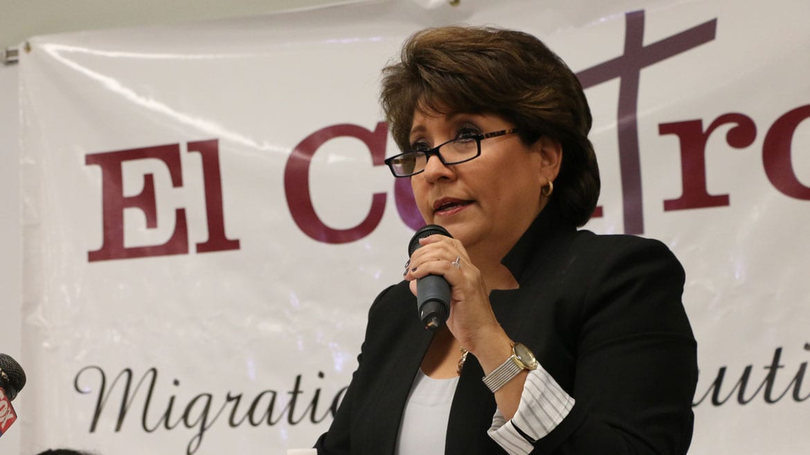 Latina woman speaks at a podium