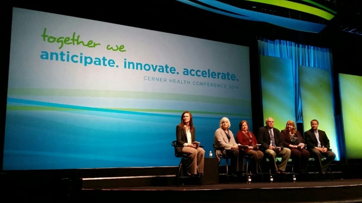 Photo of 6 panelists on stage with Cerner Health Conference logo on large screen
