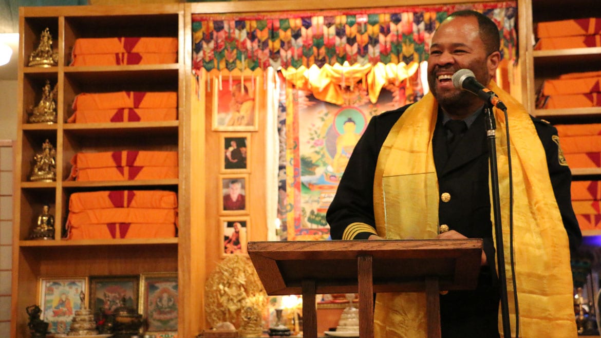 Police Chief Darryl Forte stands at a podium holding a glass award.