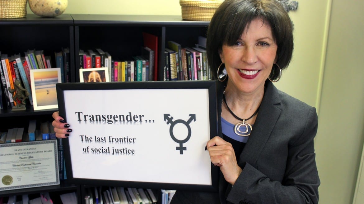 Image of woman holding a sign that says "Transgender... The last frontier of social justice"