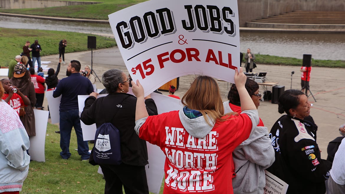 Picture of people marching and holding sign that says "Good Jobs, $15 for all"