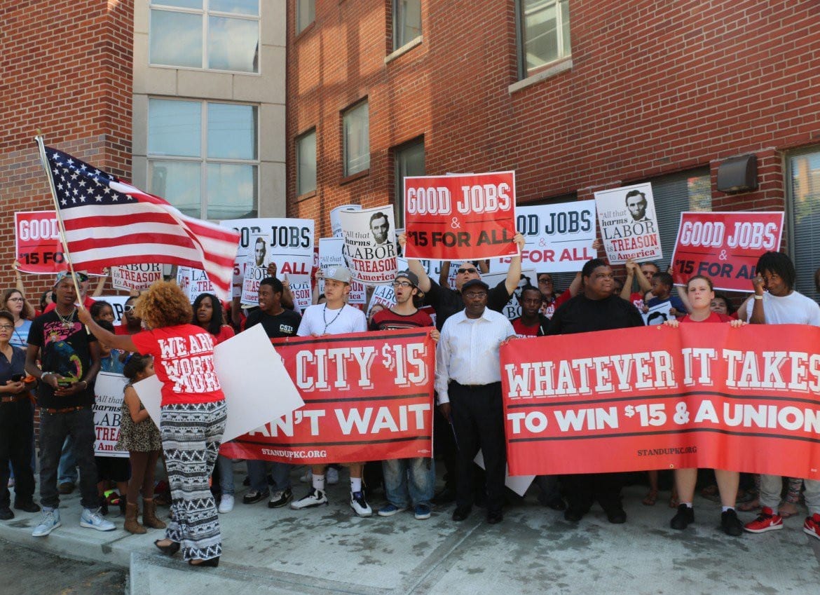 Protestors stand outside building