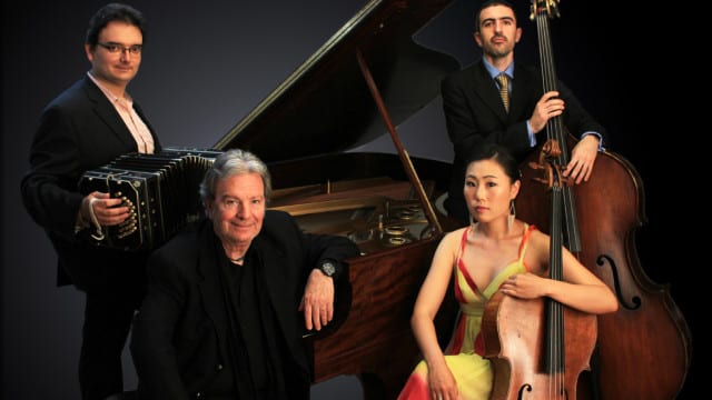 Four musicians around a piano