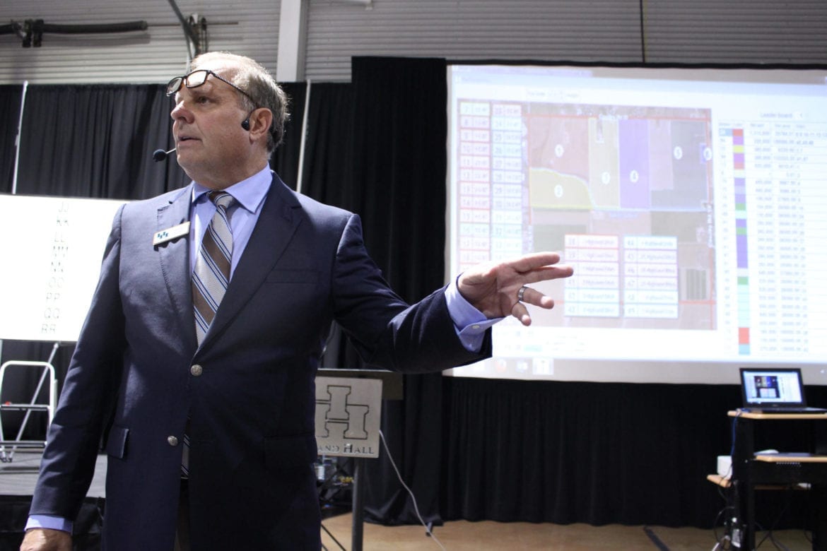 A man stands next to a slideshow.