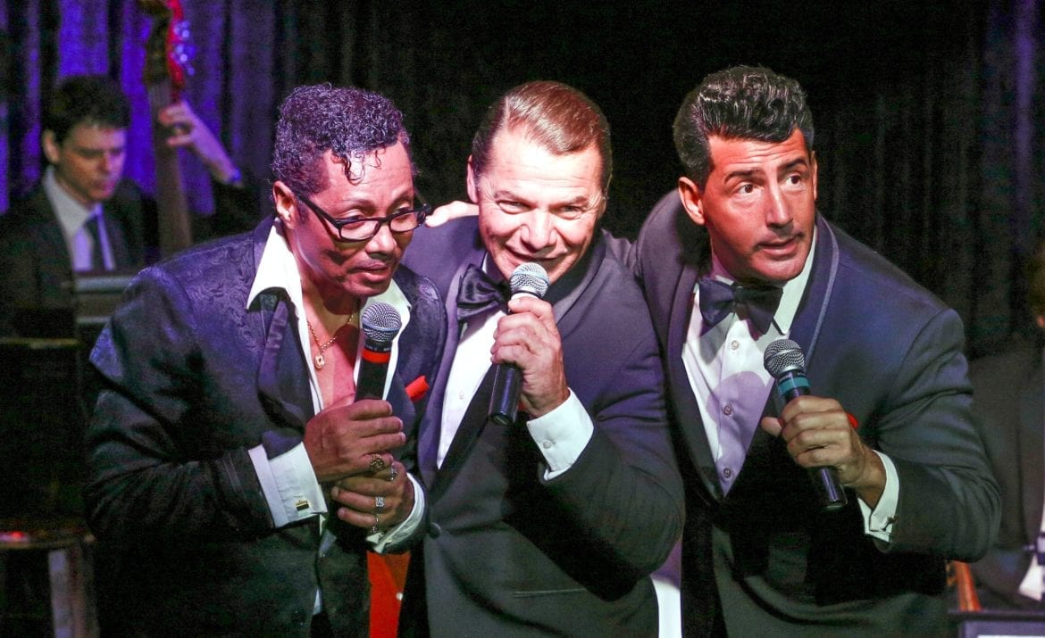 Three men singing on stage.