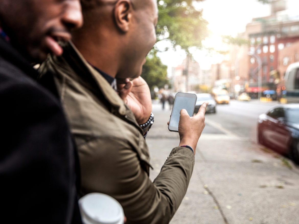 A man using a smartphone to hail a cab