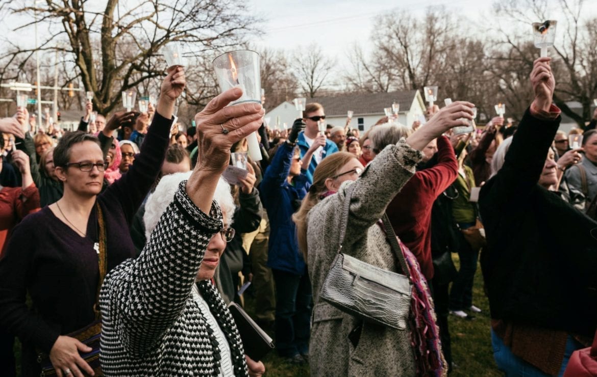 People raise their candles as a commitment to contact their representatives on behalf of immigrants and refugees.