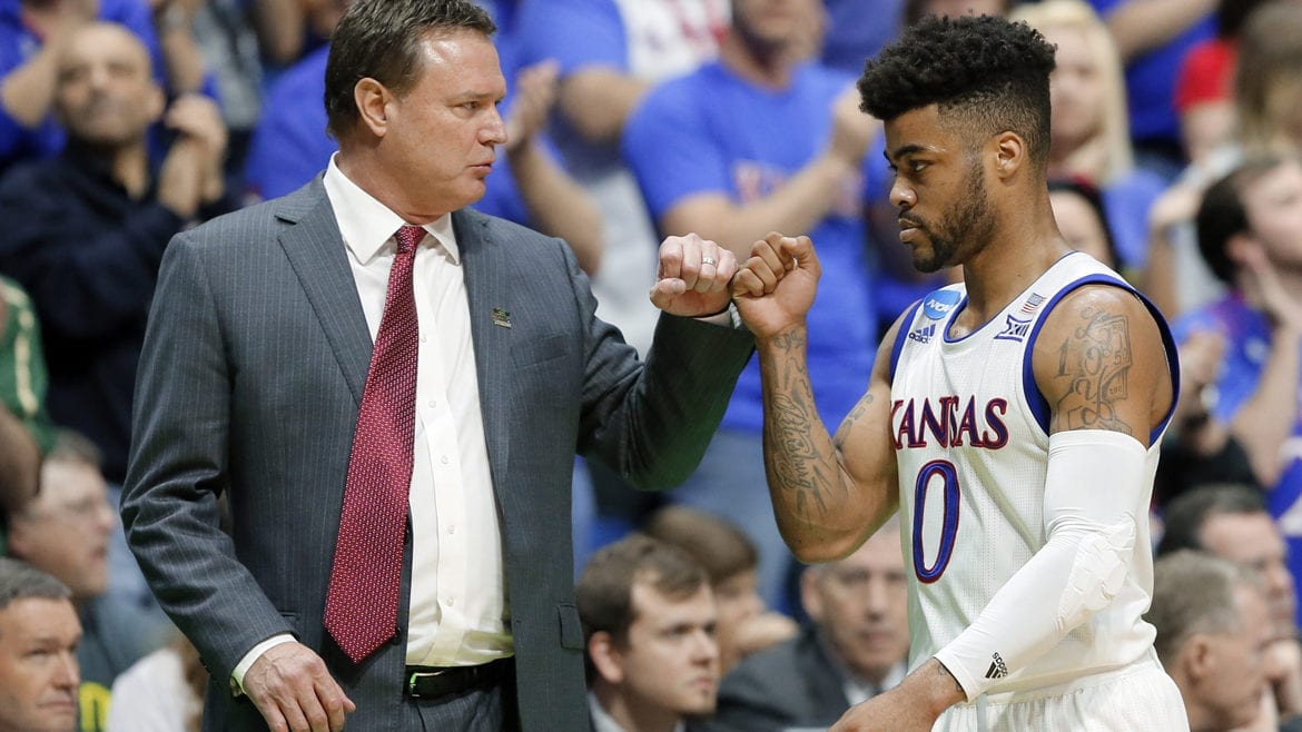 A basketball coach and player bump fists