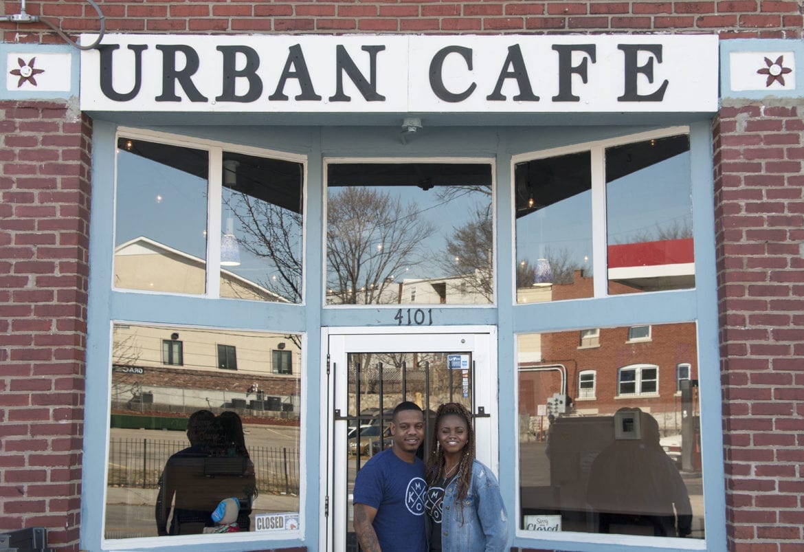 A man and woman standing outside a restaurant.