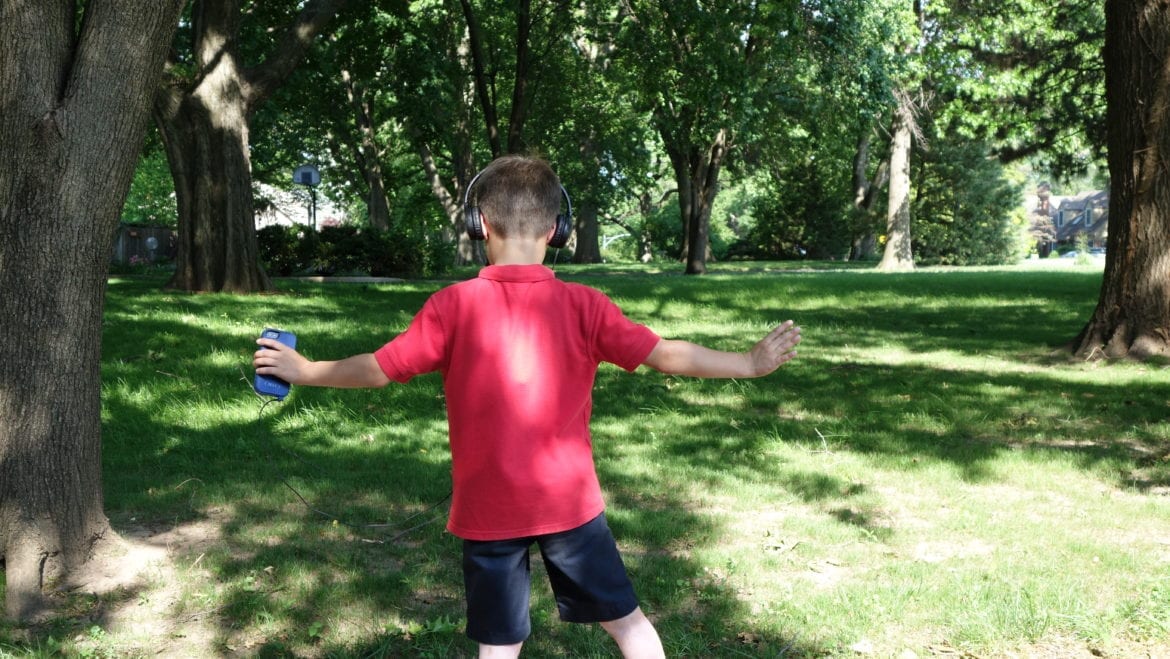 A young boy dancing with a Walkman