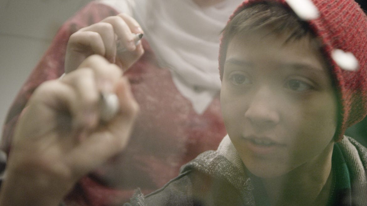 a boy writing on a board