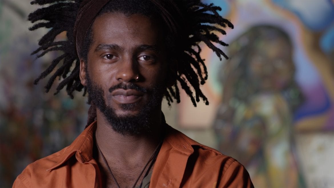 A man standing in front of a mural