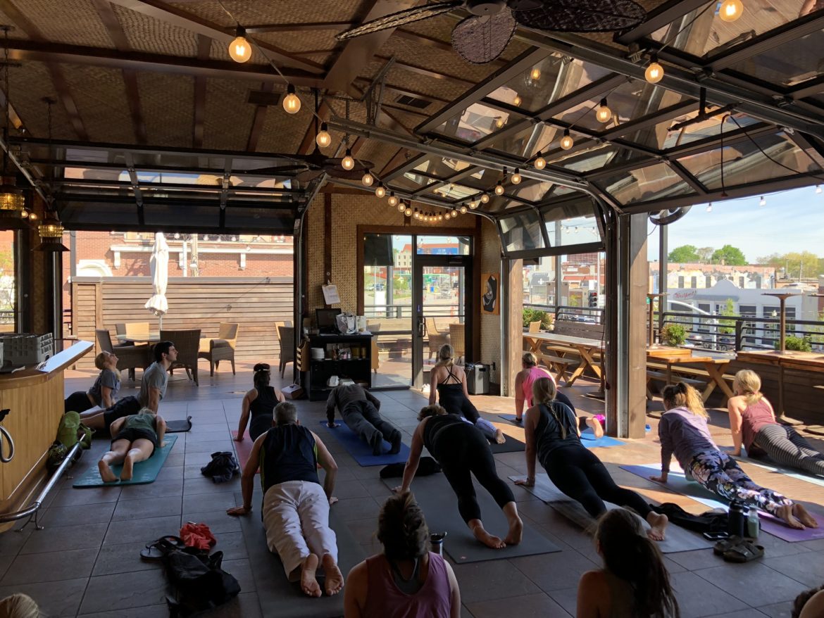 A yoga class goes through a rooftop sequence.