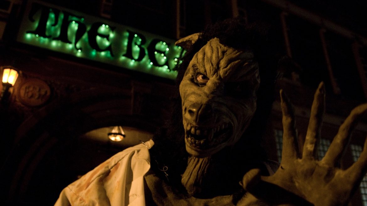 A beast-like creature waves at the camera in front of The Beast Haunted House.