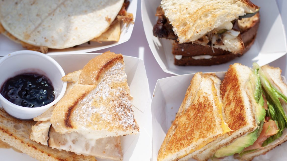 Four grilled cheese sandwiches on a tray