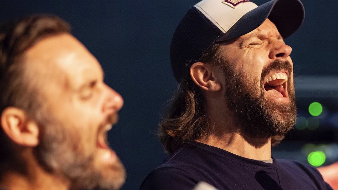 Jason Sudeikis sings into a microphone