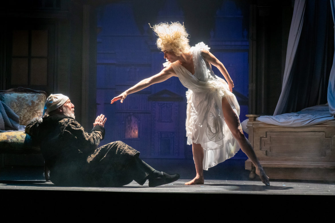 Ebenezer Scrooge cowers on the floor. 