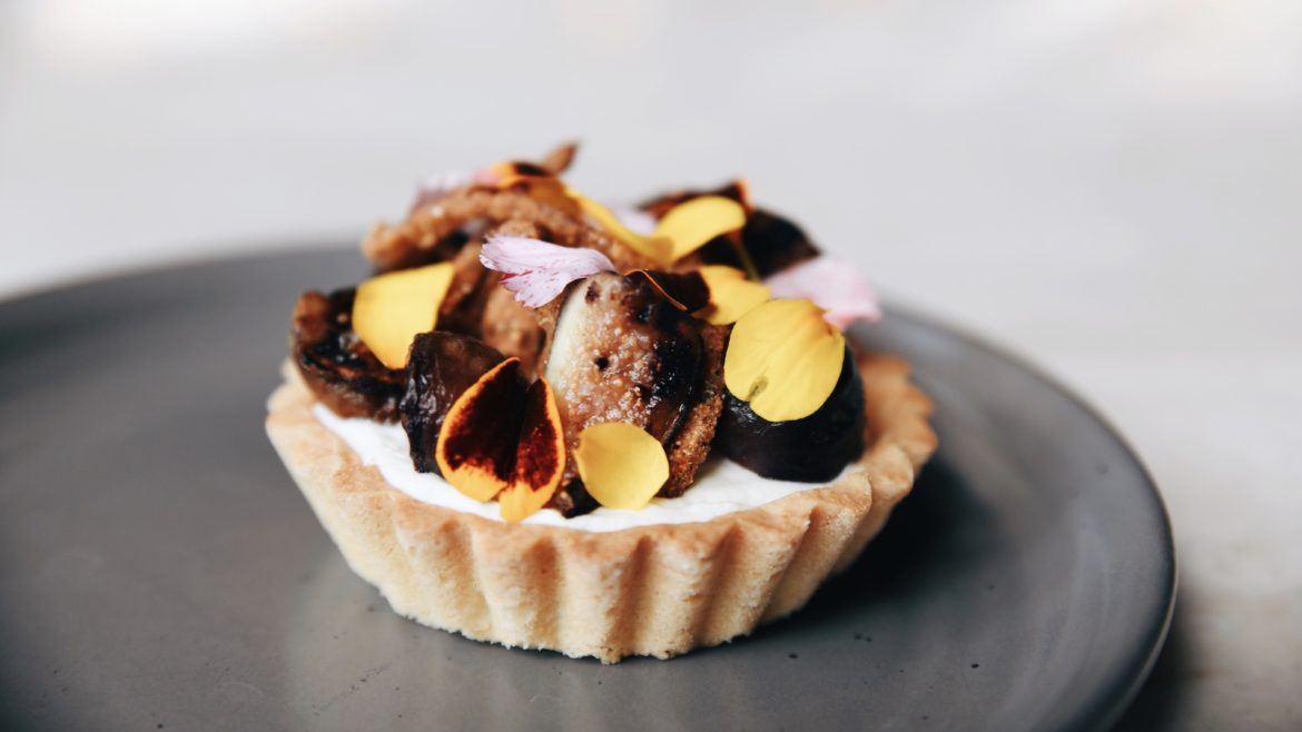 A caramelized onion tart sits on a platter.