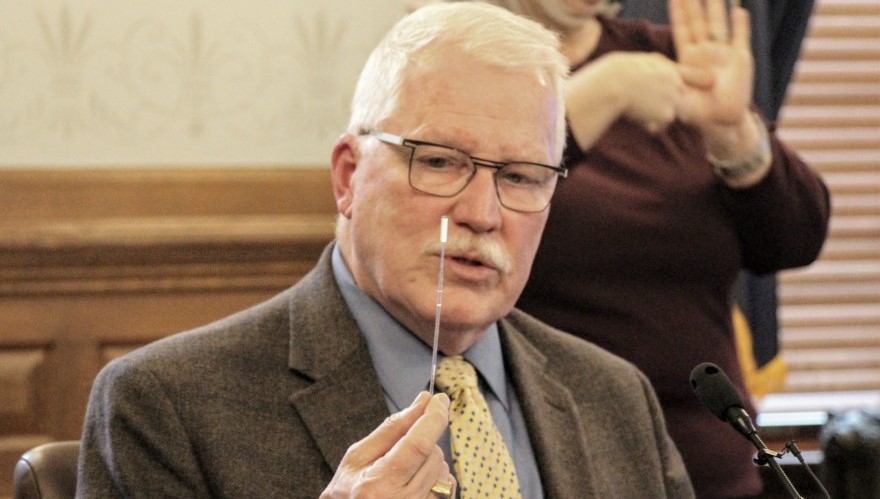 Kansas Health Secretary Lee Norman displays a swab used for COVID-19 testing.