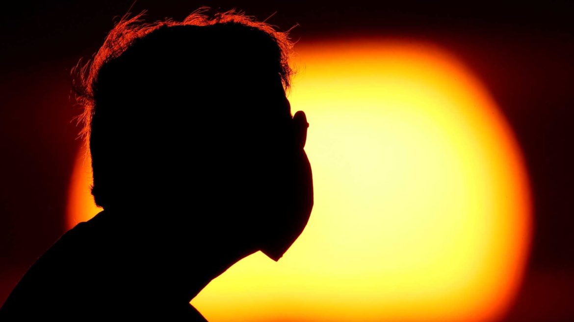 Man wearing a mask at sunset.
