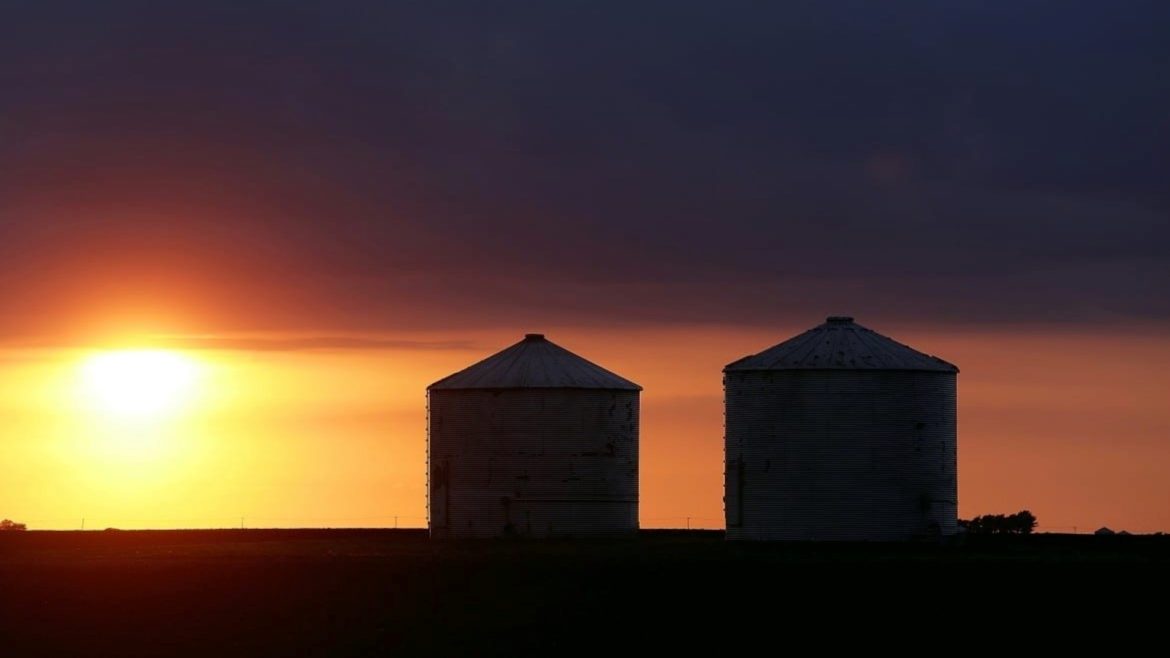 Storm clouds form over grain bins.