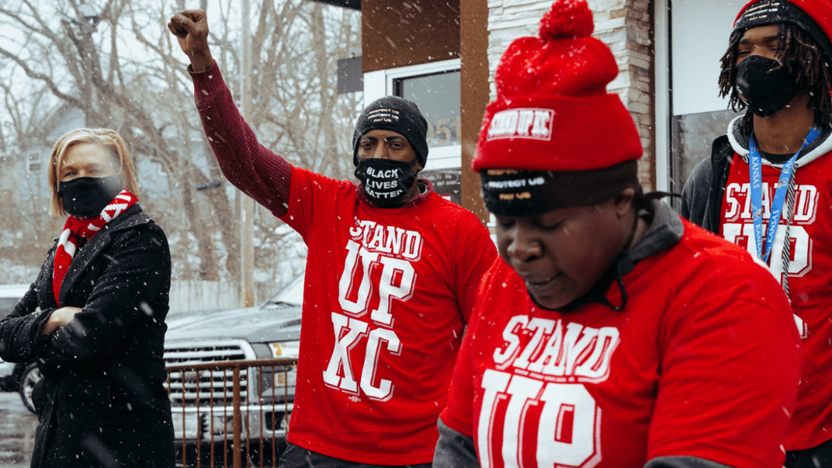 McDonald's worker Terrence Wise holds his fist up in solidarity as Fran Marion, another local McDonald's worker, speaks at the Fight for $15 rally on Jan. 15 in front of the Van Brunt McDonald’s in Kansas City,