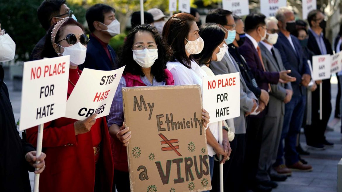 Demonstrators hold signs during a press conference calling to a halt on violence against Asian Americans
