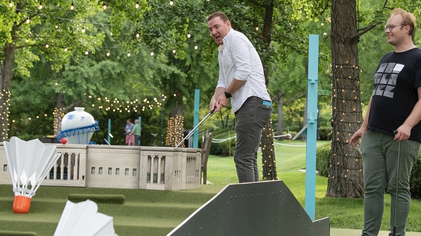 A person plays mini golf on the Nelson-Atkins lawn.