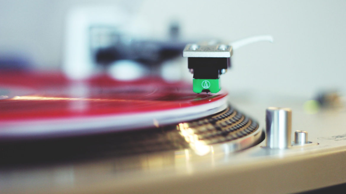 A red vinyl album spins on a turntable.