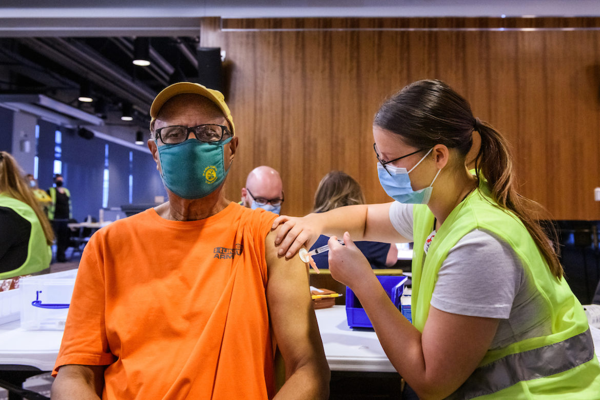Earl Coleman receives his COVID-19 vaccine from MU Health Care staff nurse Paige Spry, RN, during MU Health Care’s vaccination clinic in the Walsworth Family Columns Club at Faurot Field in Columbia, Mo. on Thursday, Feb. 4, 2021.
