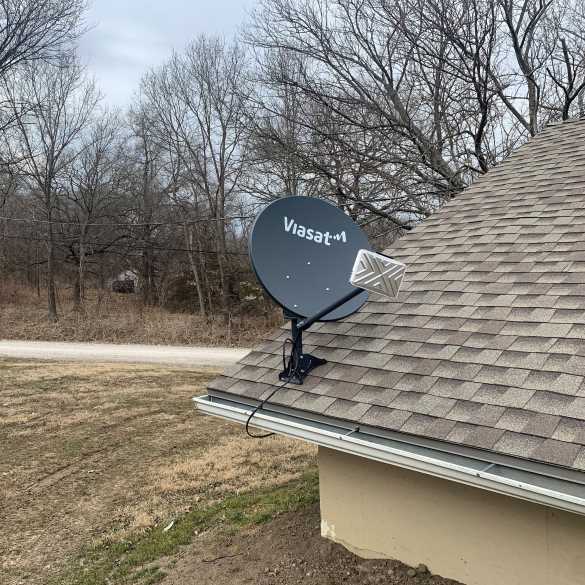 The Black family's satellite outside of their home. When it snows, they have to knock packed snow off of the dish to get a connection.