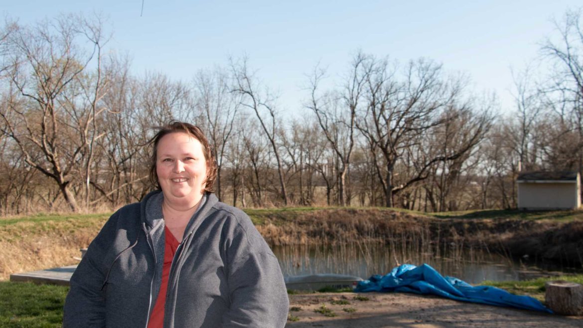 Meagan Black stands in front of the trees that block the tower on top of the grain elevator in Paola, Kansas, on March 29,