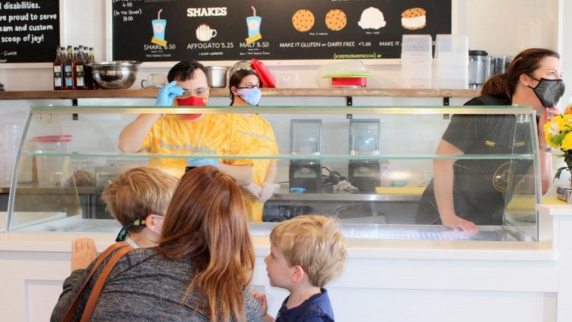 Brett Hughes waits on customers while Rachel Seaman makes ice cream and Michelle Reeves (right) serves as a coach at The Golden Scoop.