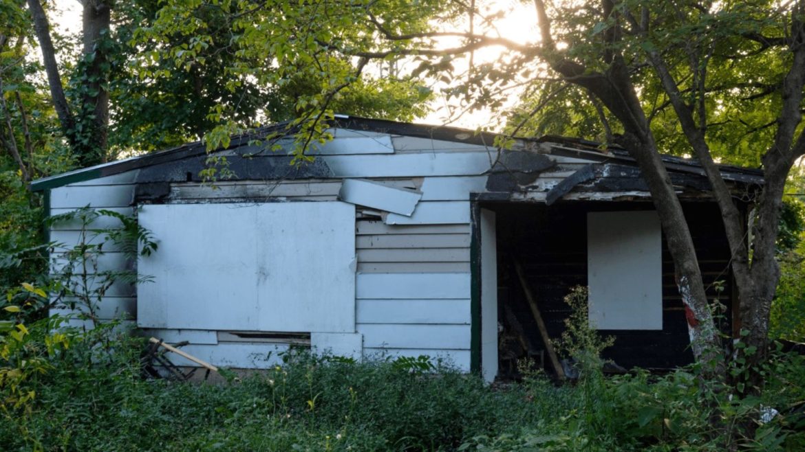 This home on 3329 Spruce Ave. has been on Kansas City's dangerous buildings list since February 2021. The owner of the property is located in Kansas.
