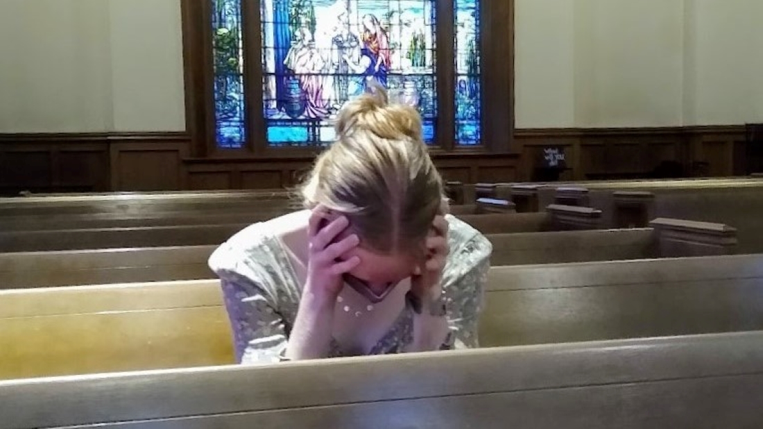 A parishioner sits alone in church.