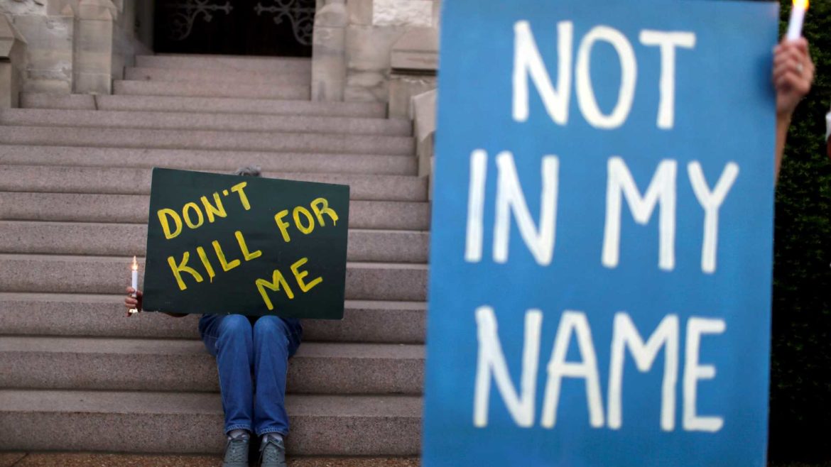 Death penalty opponents Joyce Engle, left, and Kate McCoy hold a signs as they take part in a vigil outside St. Francis Xavier College Church ahead of the scheduled execution of Missouri death row inmate Russell Bucklew on Tuesday, May 20, 2014, in St. Louis.