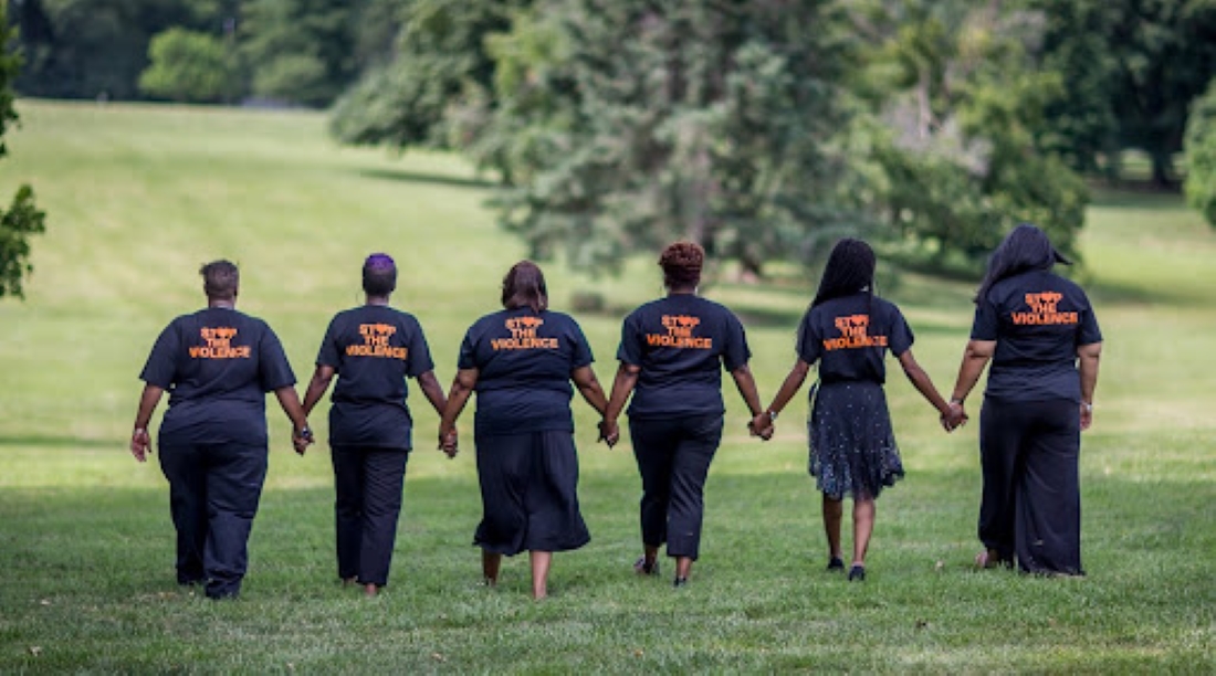 Members of KC Mothers in Charge holding hands in solidarity in Kansas City, Missouri.