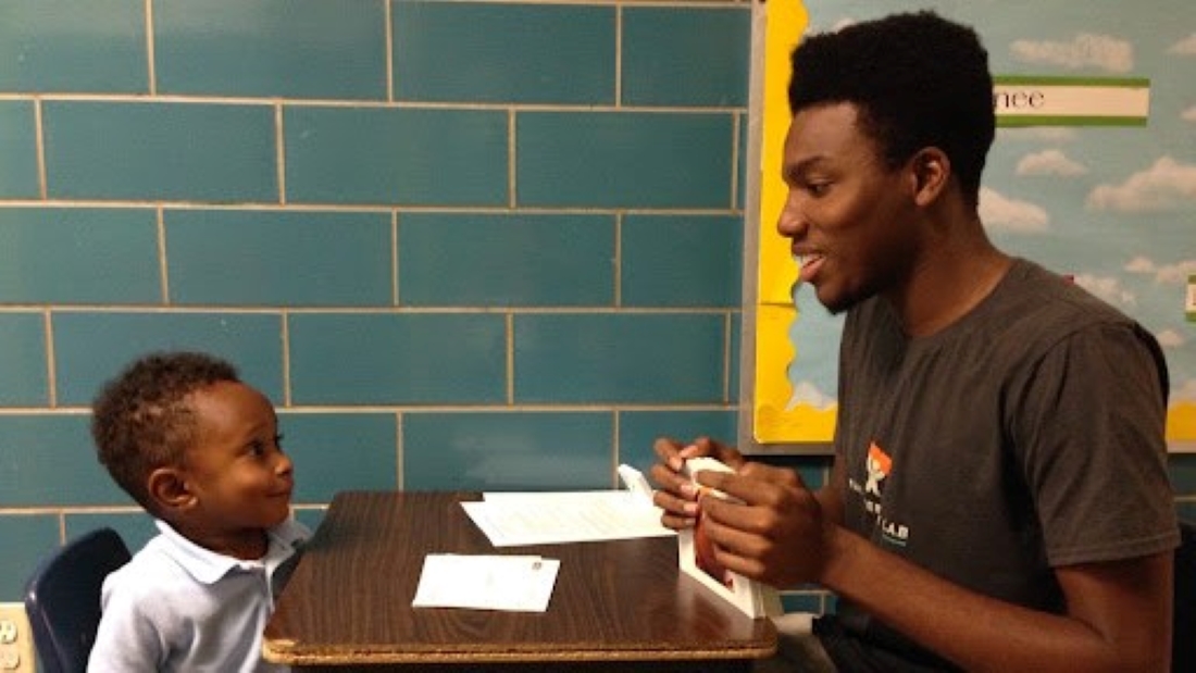 A Literacy Lab tutor teaching during a session with a young student.