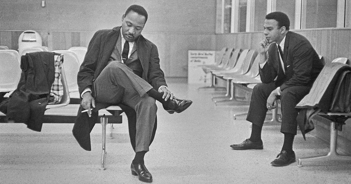Image: Martin Luther King Jr. hangs his head with a cigarette hanging in his right hand (left) and Andrew Young in 1966 at the Montgomery, Ala., airport. Credit: Bob Fitch, Stanford University Libraries, Department of Special Collections
