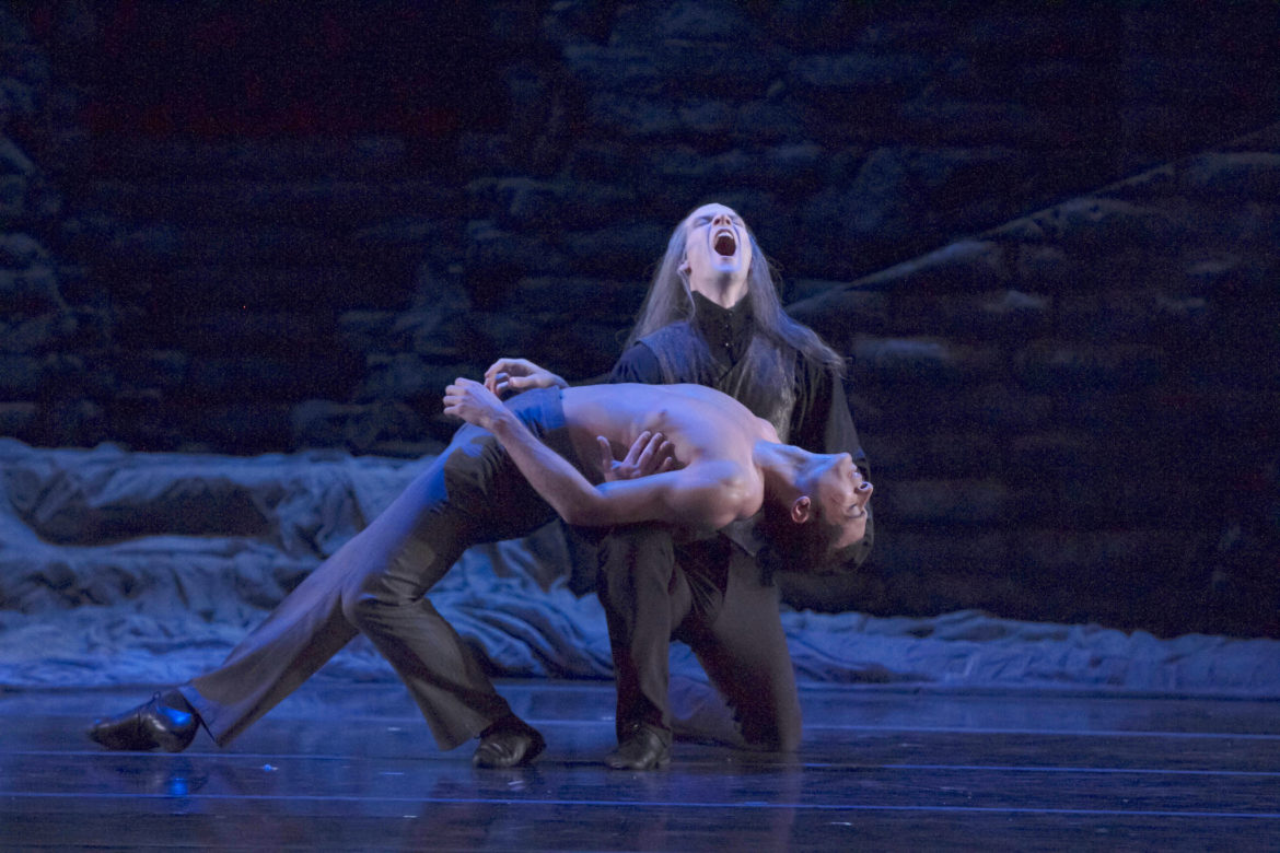 Dancers pose dramatically on stage.
