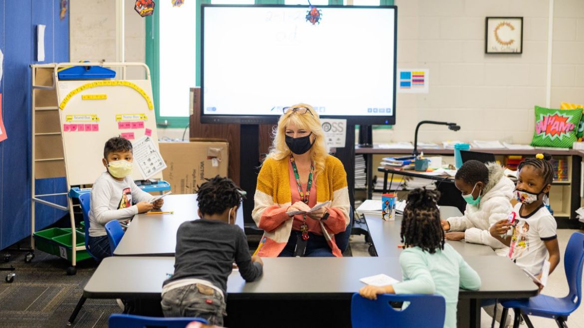 An interventionist works on reading skills with a small group of students Feb. 1 at Faxon Elementary School in Kansas City. Kansas City Public Schools has used federal COVID relief dollars to hire more staff in an effort to give students focused attention and help them catch up from pandemic-related learning loss.