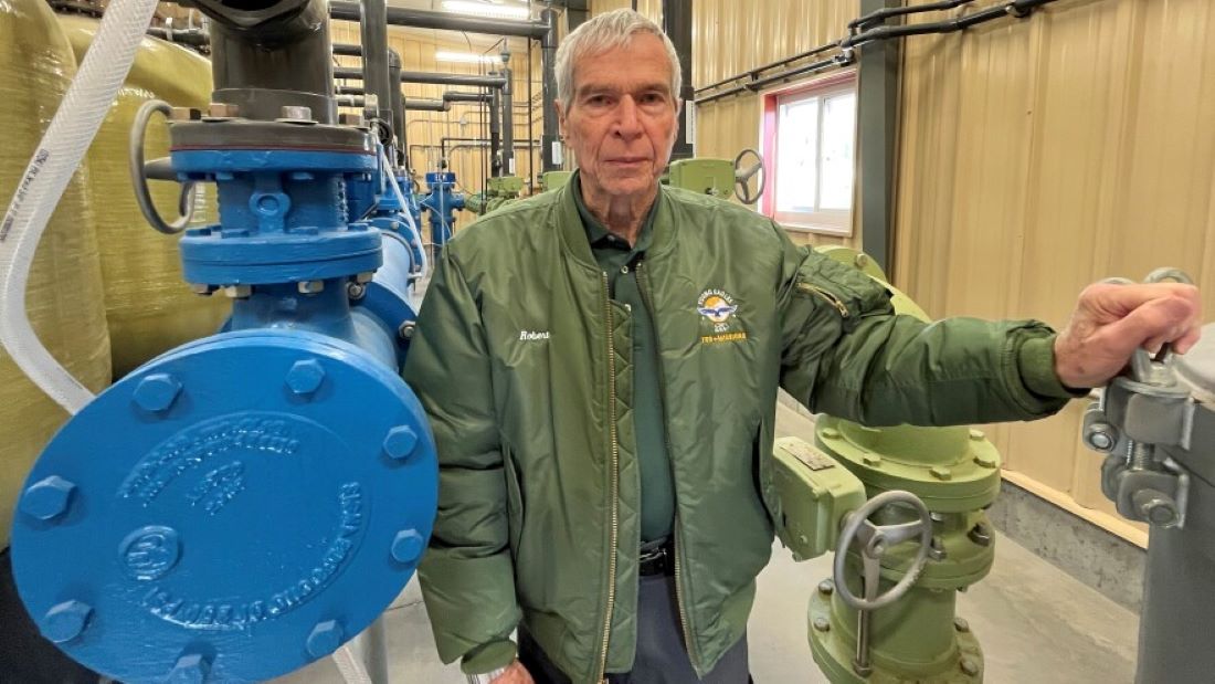 Former Haviland mayor Robert Ellis stands between pipes inside the small town's multimillion-dollar water treatment plant.