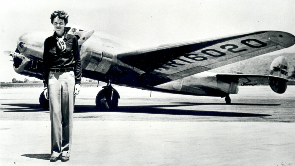 Vintage photo shows Amelia Earhart in front of a plane.