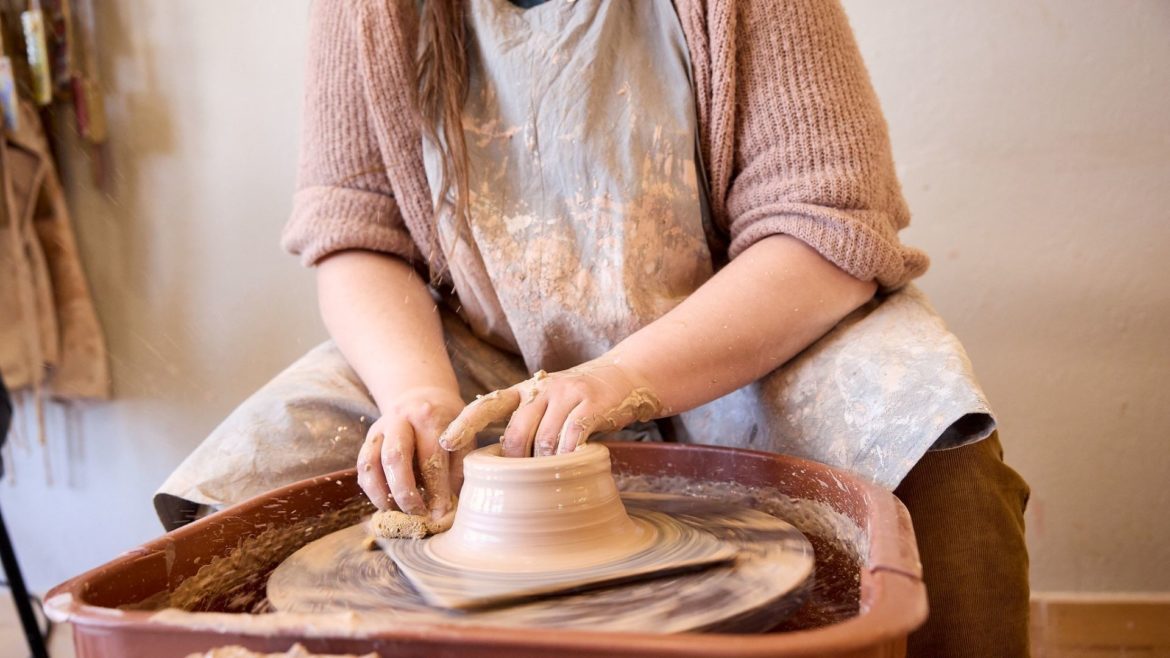 An artist working on a potters wheel at Epic Arts.
