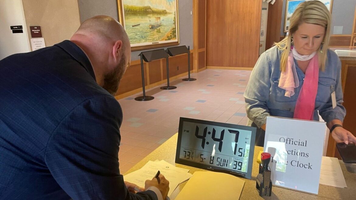 David Roland, treasurer of Better Elections Missouri, signs petition submission paperwork Sunday at the Secretary of State's office in Jefferson City.