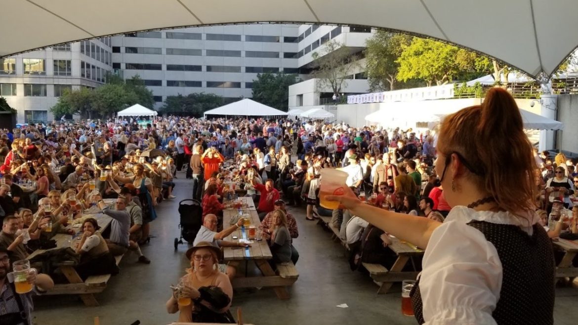 KC Oktoberfest crowd hoists a beer In celebration.